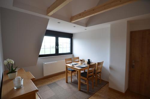 Ferienwohnung Bouten A في غيلدرن: غرفة طعام مع طاولة وكراسي ونافذة