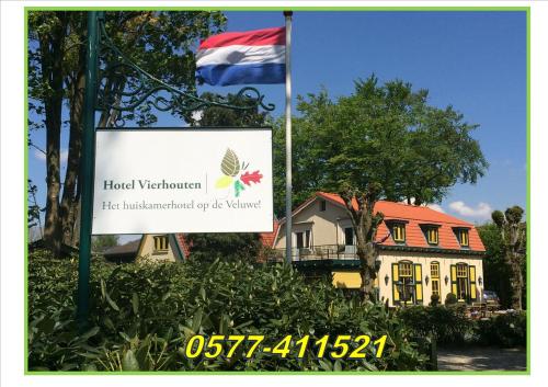 a flag and a sign in front of a house at Hotel Vierhouten in Vierhouten