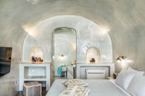 a bedroom with a bed and a mirror at Diamond Luxury Suites Collection in Oia