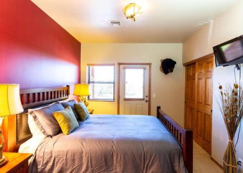ein Schlafzimmer mit einem großen Bett und einem Fernseher in der Unterkunft Elegant Cottage with Wonderful Views near FH Lake in Show Low