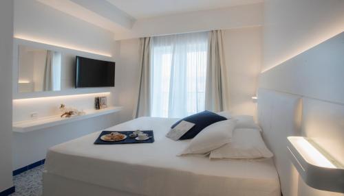 a hotel room with a bed with a tray of food on it at Lloyd's Baia Hotel in Vietri sul Mare