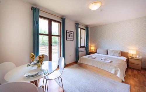 a bedroom with a bed and a table and chairs at Mountain View Aparthotel in Bansko