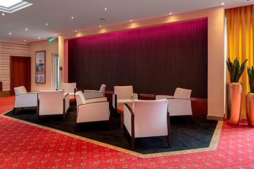 a conference room with chairs and a large wall at Hotel Schweizer Hof Thermal und Vital Resort in Bad Füssing