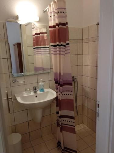 a bathroom with a sink and a shower curtain at Anna Studios in Agios Prokopios