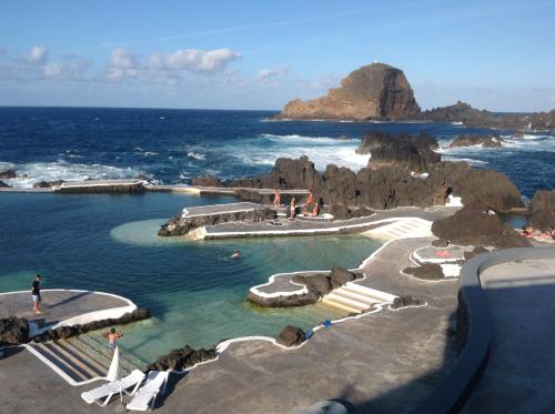 a view of a beach with rocks in the water at Pensão Fernandes in Porto Moniz