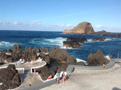a group of people on the beach near the ocean at Pensão Fernandes in Porto Moniz