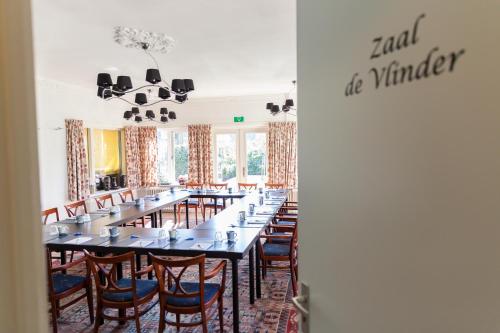 a long dining room with a long table and chairs at Hotel Vierhouten in Vierhouten