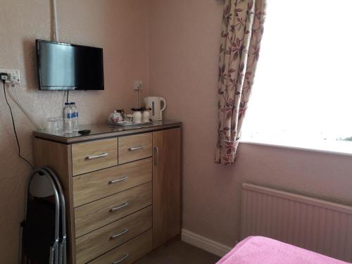 Un dormitorio con un tocador con TV. en The Inn Place, en Skegness