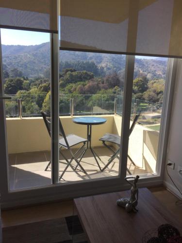 a balcony with a table and a view of the mountains at Papudo LPV in Papudo