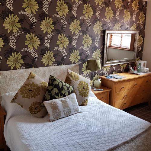 a bedroom with a bed and a mirror on a wall at The Blue Bell Inn in Weaverthorpe