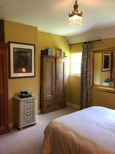 a bedroom with a bed and a dresser and a window at Corriebeg Cottage in Borris