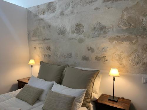 a bedroom with a bed with pillows and two lamps at El Apartamento de la Yaya in Toledo