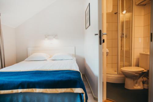 a bedroom with a bed and a bathroom with a toilet at Economy Hotel in Tallinn