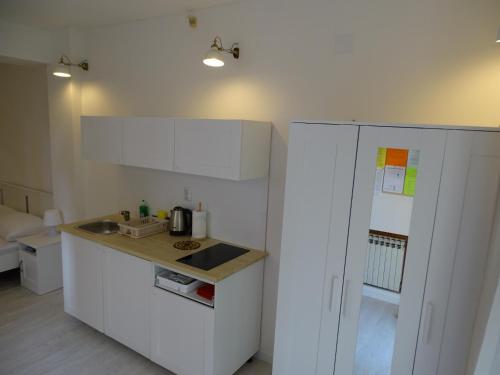 a white kitchen with a sink and a refrigerator at Job studio apartments in Split