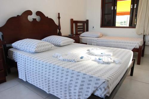 two beds in a bedroom with towels on them at Hotel Águas Vivas in Caraguatatuba
