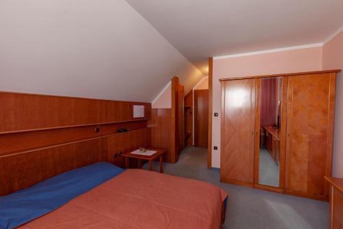 a bedroom with a bed and a wooden cabinet at Gostišče Prosnik in Ormoz