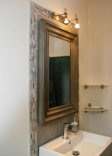 a bathroom with a sink and a mirror at L ESCALE EN BEAUCE in Maisons