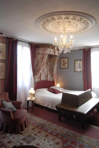 a bedroom with a bed and a chandelier at Chambres d'hôtes Logis Du Jerzual in Dinan