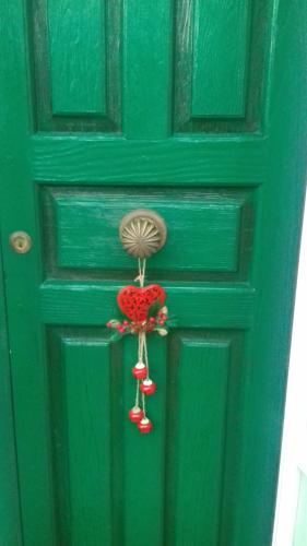 een groene deur met een deurklopper erop bij L' Albarosa affittacamere e b&b in Spigno Saturnia