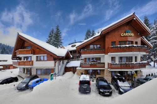 a ski lodge with cars parked in the snow at Villa Gardenia in Donovaly