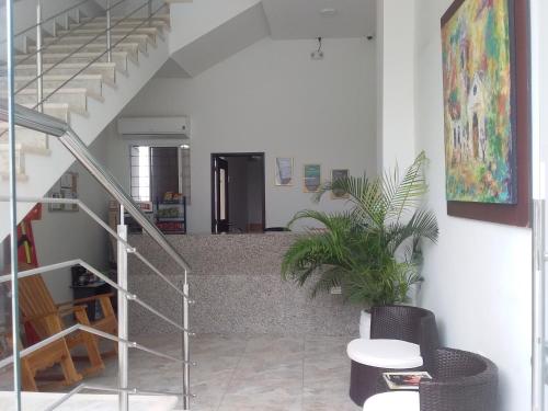 a staircase in a room with a table and a plant at Perla De La Sabana in Corozal