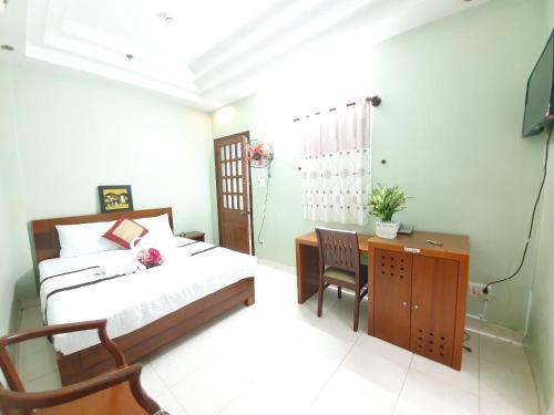a bedroom with a bed and a desk and a television at Khách sạn Trường Sơn in Ho Chi Minh City