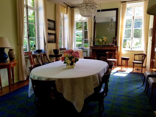 a dining room with a table with a vase of flowers on it at Le Bocage Fleuri in Mons