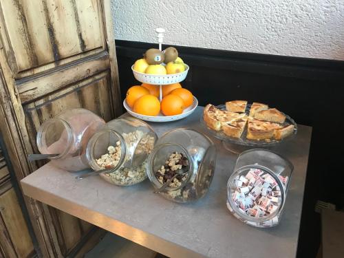 Ein Tisch voller Schüsseln mit Essen und einem Kuchen in der Unterkunft Hotel du Centre - Restaurant le P'tit Gourmet in Tonnerre