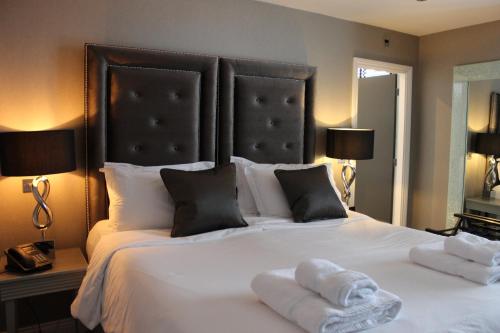 a bedroom with a large white bed with towels on it at The Bold Hotel; BW Signature Collection in Southport