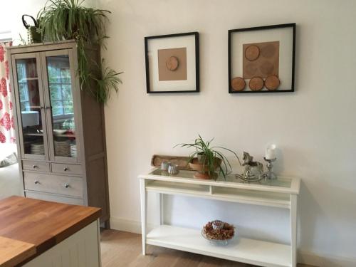 a living room with a white table with plants on the wall at Landhaus Roidergütl in St. Wolfgang