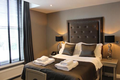 a bedroom with a large bed with towels on it at The Bold Hotel; BW Signature Collection in Southport