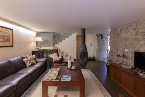 ein Wohnzimmer mit einem Sofa und einem Holzofen in der Unterkunft Boutique Country House w/ Pool by Host Wise in Travanca
