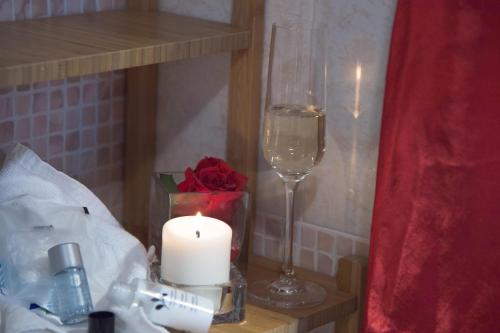 a candle and a glass of wine next to a candle at Agriturismo Ai Carpini in Marcon