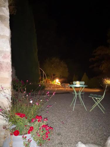 a table and chairs in a yard at night at Castel Mazars in Castelnau-de-Montmiral