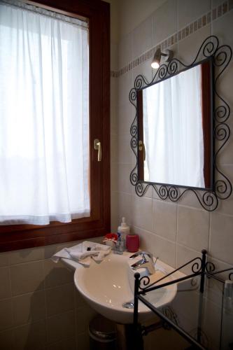 a bathroom with a sink and a mirror and a window at Agriturismo Ai Carpini in Marcon