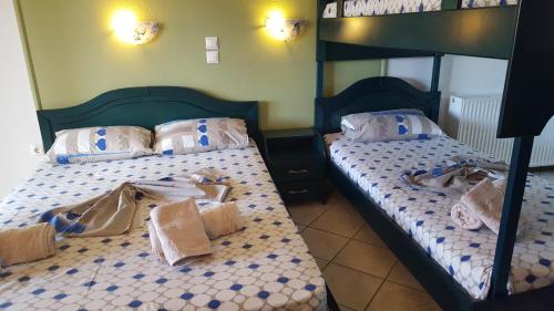 two twin beds in a bedroom with clothes on them at Petrino 2 by Vasileia in Sarti