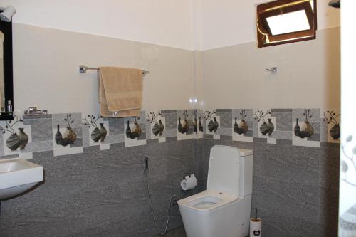 a bathroom with a toilet and a sink at White House Family Stay in Maspota