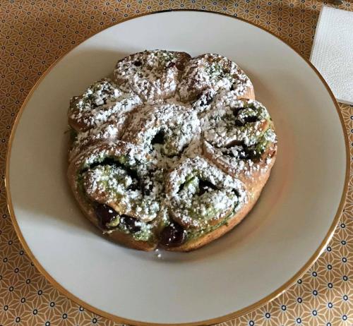 a doughnut with powdered sugar on a plate at L ESCALE EN BEAUCE in Maisons