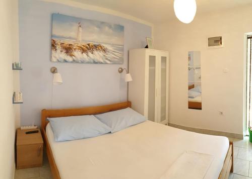 ein Schlafzimmer mit einem Bett und einem Wandgemälde in der Unterkunft Apartments Andelic in Sveti Filip i Jakov