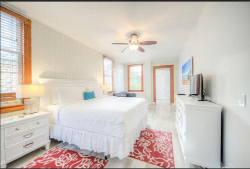 a white bedroom with a bed and a ceiling fan at The Bartlum by Brightwild-Luxurious Studio in Key West