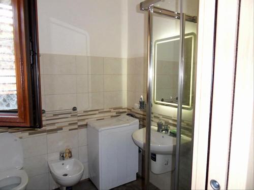 Un baño con lavabo, inodoro y ducha. en belvedere, en Castelsardo