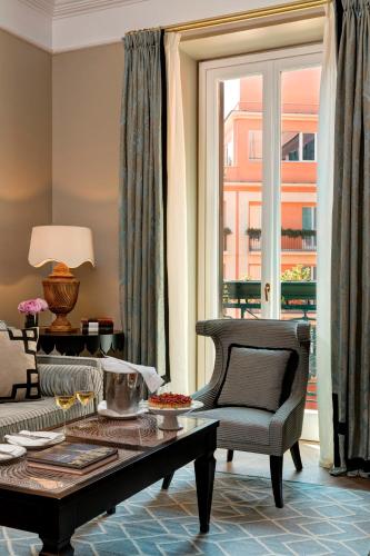 a living room with a couch and a coffee table at Rocco Forte Hotel De La Ville in Rome