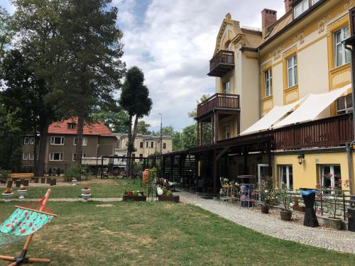 a building with a kite in front of a yard at Hotel Bella in Jelenia Góra