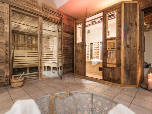 una sala da pranzo con pareti in legno e una stanza con tavolo di Appart & Chalet Montana Hochfügen (Contactless Stay) a Hochfugen