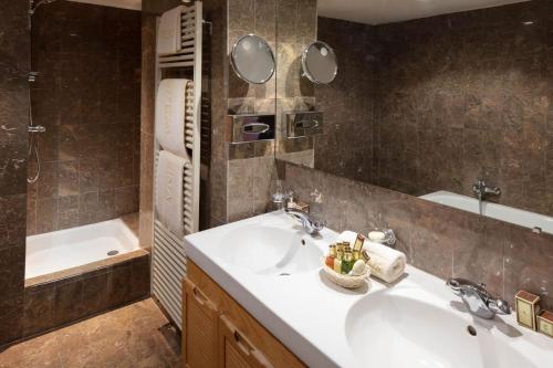 谷雪維爾的住宿－卡利娜酒店，浴室配有盥洗盆和浴缸。