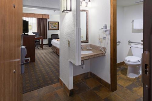 a hotel room with a bathroom with a toilet and a sink at Ramkota Hotel - Casper in Casper