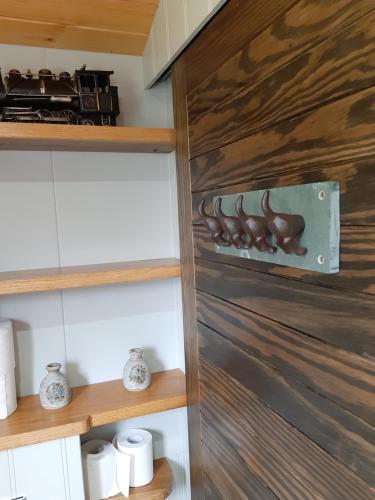 a wooden door in a bathroom with wooden shelves at Annascaul Train Carriage suit couple and 2 children in Annascaul