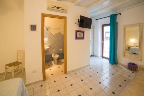 オルビアにあるOlbia Domus Innのバスルームとベッドルームが備わる広い客室です。