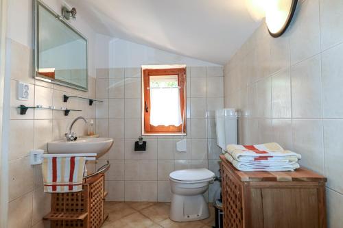 un bagno con lavandino, WC e finestra di Waimarie a Fažana