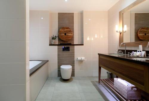 a bathroom with a tub and a toilet and a sink at Macdonald Windsor in Windsor